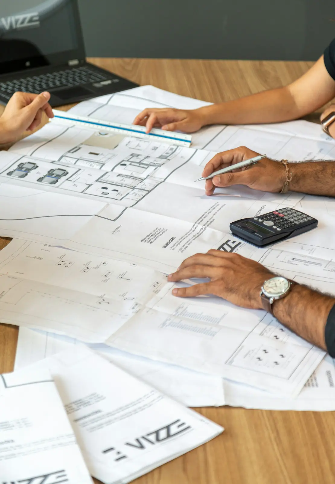 Profesionales coordinando planos y antecedentes de un proyecto